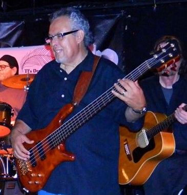 Frank Sanchez playing bass guitar at a live performance