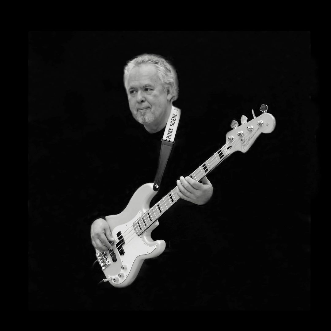 Frank Sanchez holding a white bass guitar — PRIME SERIES